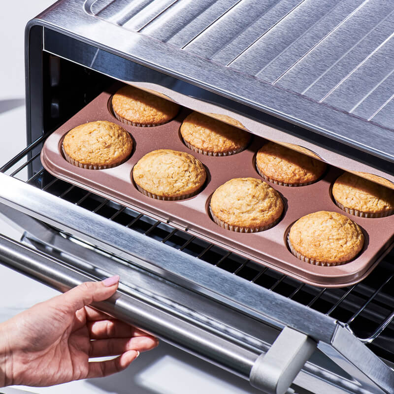 Placing vanilla cupcake batter into the oven